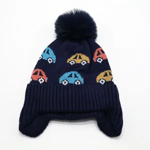 Navy blue knitted winter hat for kids with car patterns and a large faux fur pompom