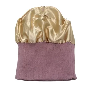 Detalle del gorro de punto con forro de satén dorado y tejido de punto acanalado rojo