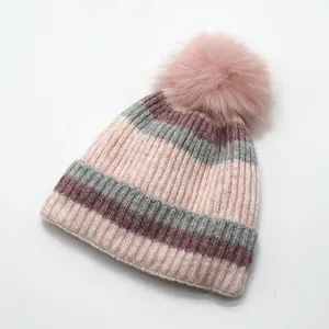 Close-up of pink and grey striped knit hat with soft pom-pom and thick lining