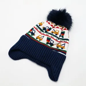 Details der Stricktextur und Kran-Jacquardmuster auf einer Kinder-Wintermütze mit Bommel