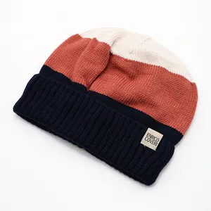 Close-up of tricolor ribbed knit beanie with soft warm fabric and logo patch detail