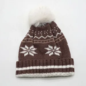 Bonnet en tricot marron avec motifs flocons de neige blancs et pompon en fausse fourrure
