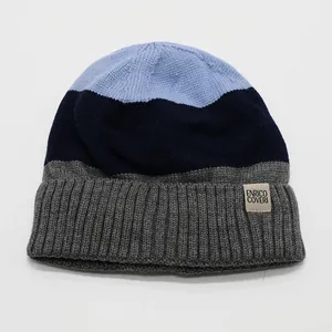 Close-up of color-block knit beanie showing blue and grey tones with a brand patch
