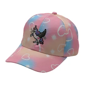 Dettaglio del ricamo a unicorno e motivi a cuore sul berretto sfumato rosa e blu