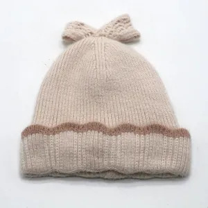 Bonnet tricoté beige pour enfants avec un grand nœud et un bord à rayures marron