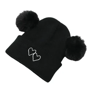 Kids black knit beanie with double pom-poms and cute heart embroidery for winter