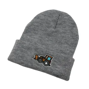 Gros plan détaillé sur la broderie de bulldozer d'un bonnet en tricot gris pour enfant