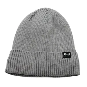 Bonnet en tricot gris pour hommes et femmes avec écusson tendance et revers classique