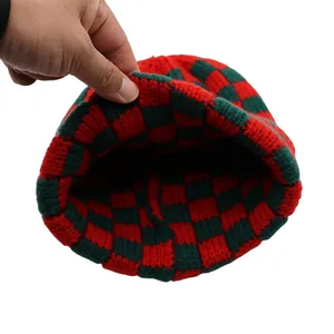Dettaglio del cappello in maglia a scacchi rossi e verdi che mostra trama ed elasticità