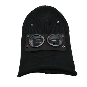 Detail of black ribbed knit balaclava featuring integrated protective goggles with snap buttons