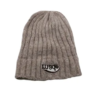Detailansicht der haferbraunen Strickmütze mit Rippenmuster und ebsm-Stickerei