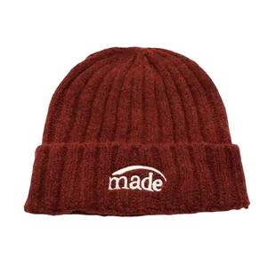 Dicke dunkelrote Strickmütze mit weißer made Buchstabenstickerei und gerippter Textur für Winter