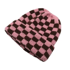 Dettagli della trama a maglia del berretto a scacchi rosa e marroni con risvolto