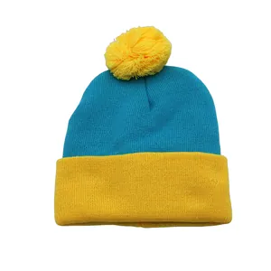 Winter knitted beanie with color block design in teal and yellow featuring a top pom-pom