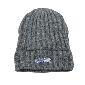 Vista dettagliata del berretto in maglia grigio scuro con ricamo CHERRY BOMB blu e bianco
