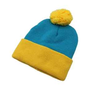 Close-up of blue and yellow knit beanie with a fluffy yellow pom-pom and soft texture