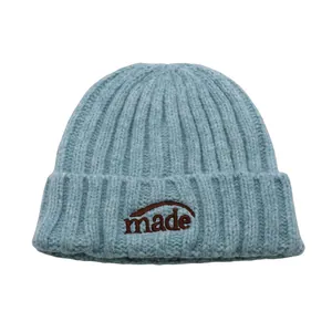 Nahaufnahme hellblaue Strickmütze mit Rippenmuster und braunem Made-Schriftzug