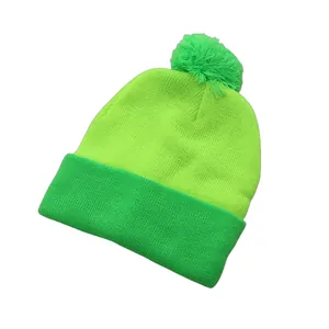 Close-up of knit texture on bicolor neon green winter beanie with a soft pom pom