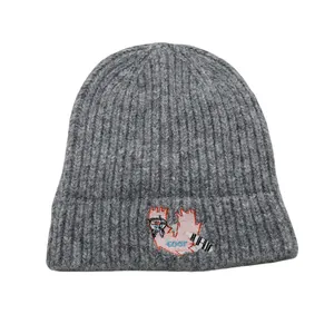 Close-up of grey knit beanie with cartoon embroidery and GOOF text detail