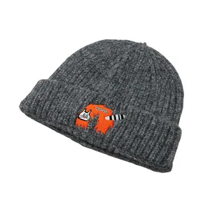 Detailed view of the dark grey ribbed knit beanie with orange cat embroidery and COOL text
