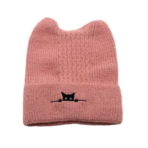 Pink cable knit beanie with cat ears and small cat embroidery on the folded brim