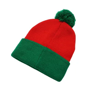 Detailed knit texture of red and green festive beanie with fluffy green pom pom top