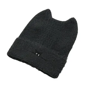 Detailed close-up of a black knit beanie featuring cute cat ears and a folded brim texture