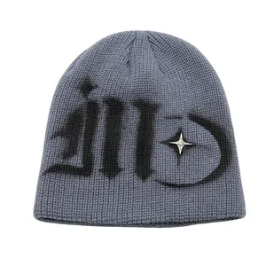 Detailed macro view of grey ribbed knit beanie with gothic lettering and metal star stud