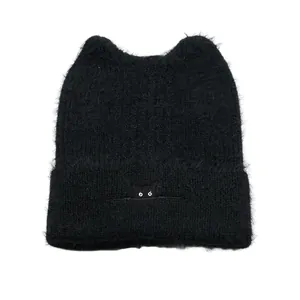 Close-up of black knitted cat ear beanie showing fuzzy texture and cat eye embroidery