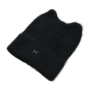 Close-up of black fluffy cat ear beanie with embroidered eye details and soft texture