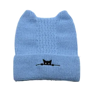 Detail of light blue knit cat ear beanie with small black cat embroidery on cuff
