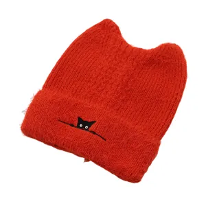 Detail of red knit cat ear beanie featuring fluffy texture and cute cat embroidery