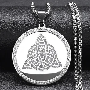 Macro shot of silver trinity knot pendant with crystal inlay and spiritual engravings