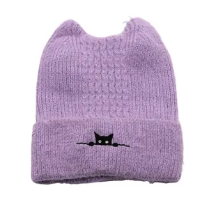 Close-up of purple knit cat ear beanie with embroidered black cat motif on the cuff