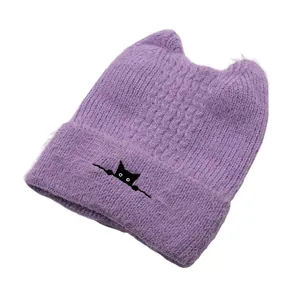 Detail of lavender knit cat ear hat with black cat embroidery and fuzzy texture