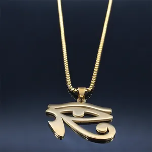 Macro shot of gold Eye of Horus pendant with bead chain reflected on black surface