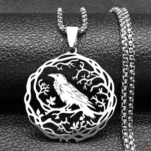Vue macro du pendentif rond évidé en acier inoxydable avec silhouette de corbeau