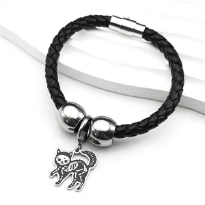 Gros plan du bracelet en cuir tressé noir avec fermoir magnétique et pendentif chat squelette