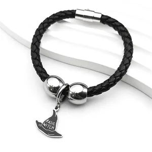 Detalle de pulsera de cuero trenzado negro con cierre plateado y colgante de sombrero