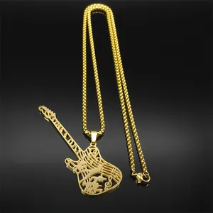 Détail du pendentif guitare doré avec motifs de notes de musique et chaîne à billes chic