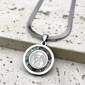 Macro detail of St. Benedict pendant with iridescent abalone shell inlay on silver snake chain