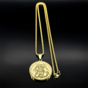 Close-up of golden Saint Michael protect us pendant with box chain on black background