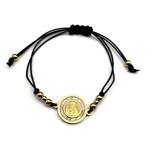 Detailed view of Saint Benedict medal on woven bracelet with iridescent pearl inlay
