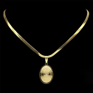 Gold St. Jude Tadeo pendant necklace with flat snake chain on a black background