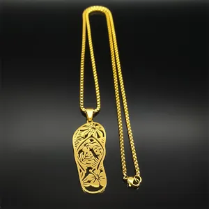 Macro shot of gold flip-flop pendant featuring intricate tropical floral laser-cut details