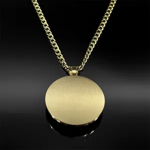 Gros plan du pendentif rond doré brossé avec chaîne gourmette sur fond noir