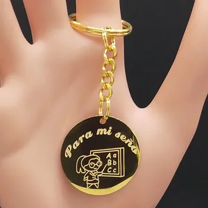 Gold stainless steel teacher keychain with engraved Spanish text and teacher icon