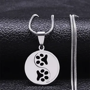 Macro detail of silver stainless steel Yin Yang dog paw necklace pendant with snake chain