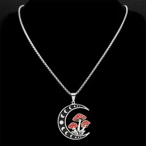 Silver crescent moon necklace with red mushrooms on black velvet neck display