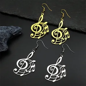 Golden and silver music note earrings featuring treble clef design on black rock background